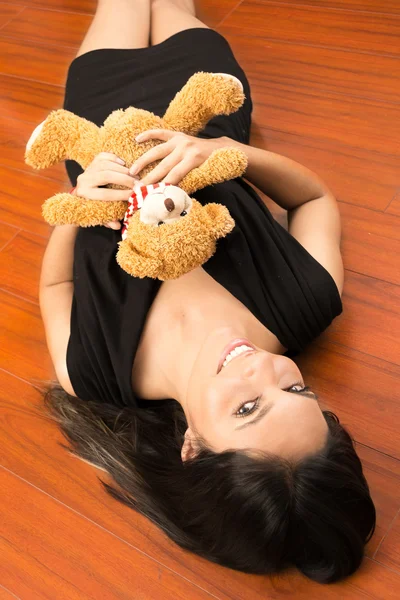 Zblízka portrét ženy držící medvídek na podlaze — Stock fotografie