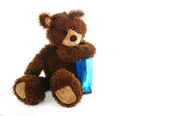 Nallebjörn med en blå transparent glas — Stockfoto