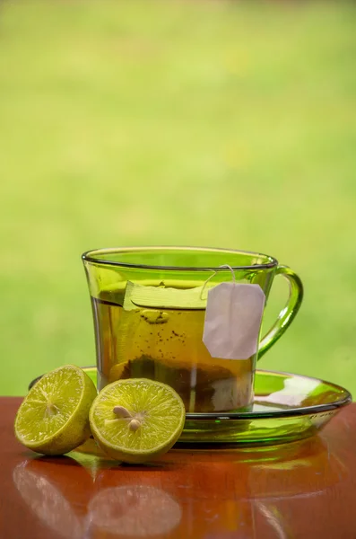 Tea cup with fresh lemons, closeup photo — Stock Photo, Image