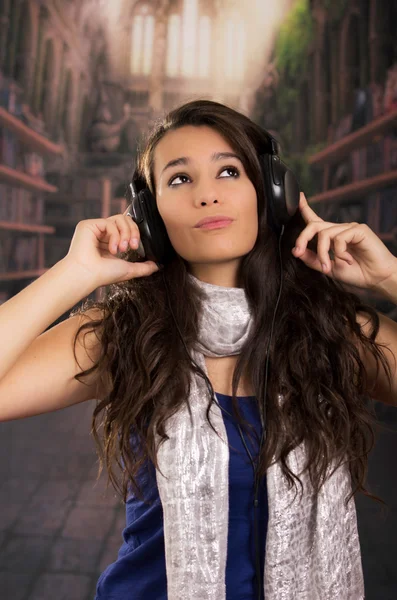 Young adult hispanic girl is listening to the music — Stock Photo, Image