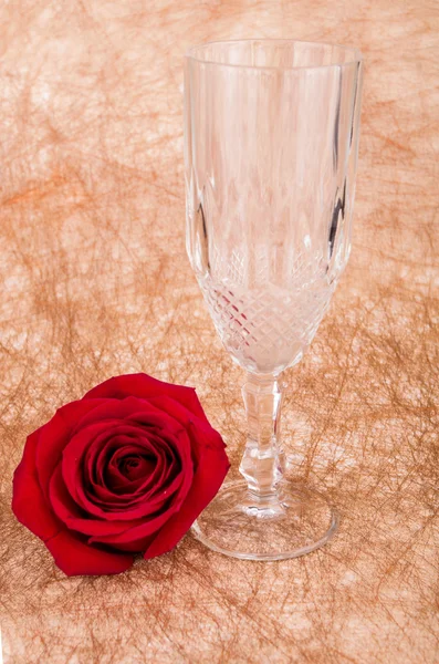 Rose with a glass on a vintage background — Stock Photo, Image