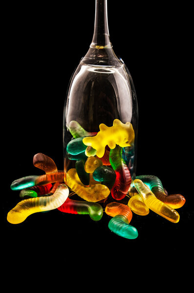 Jelly candy and a wine glass on a dark background