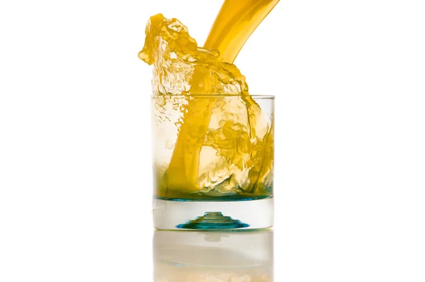 Наливання апельсинового соку бризкає на білому тлі — стокове фото