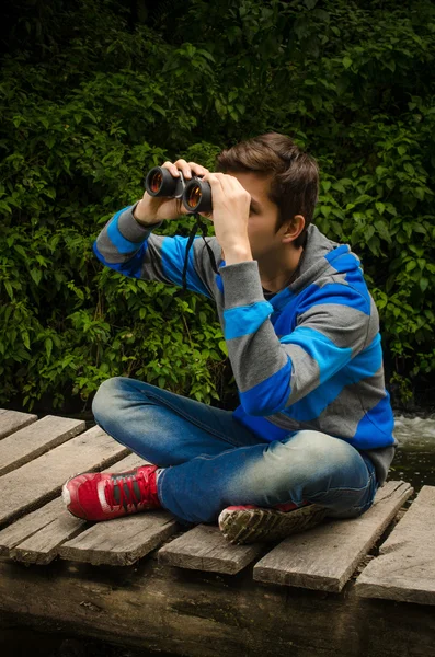 Uomo con binocolo nella foresta — Foto Stock