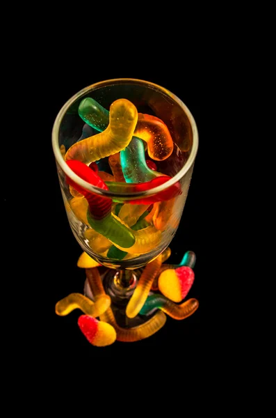 Gummy bears  and wine glass on a dark background Royalty Free Stock Photos