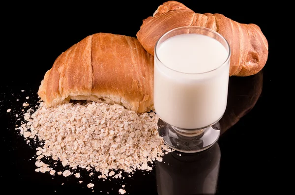 Milk oatmeal and bread in a dark background — Stock Photo, Image