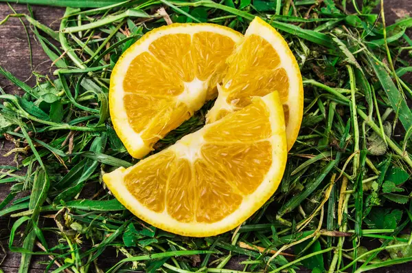 多汁的橘子切在草地上的切片 — 图库照片