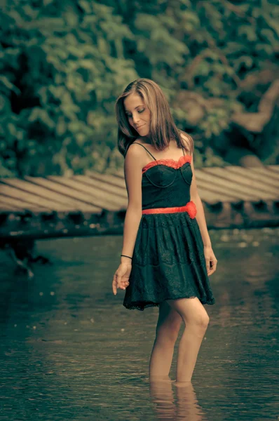 Mujer en el lago vistiendo un color dres procesado — Foto de Stock