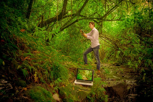 Hombre usando tableta con portátil en el bosque —  Fotos de Stock