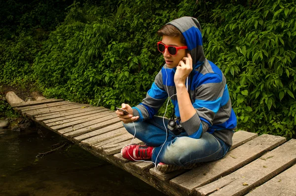 Genç adam ormanda müzik dinlemek — Stok fotoğraf