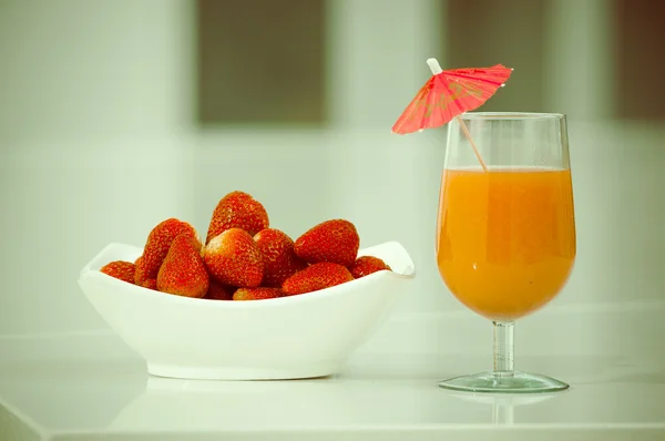 Morangos em uma tigela e suco de frutas orgânicas — Fotografia de Stock