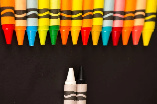 Colored versus black and white crayons — Stock Photo, Image