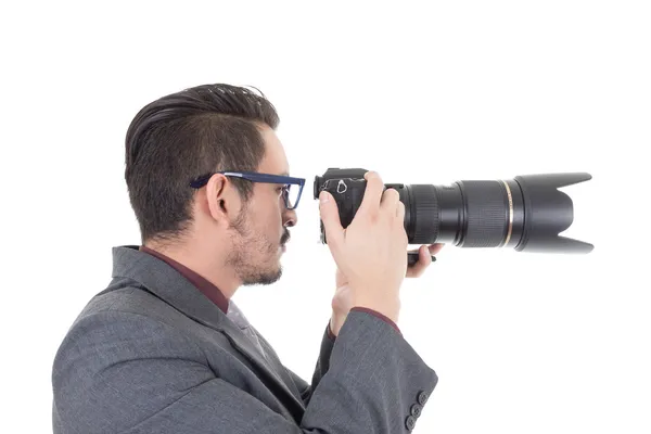 Jovem de terno tirando uma foto com câmera profissional — Fotografia de Stock