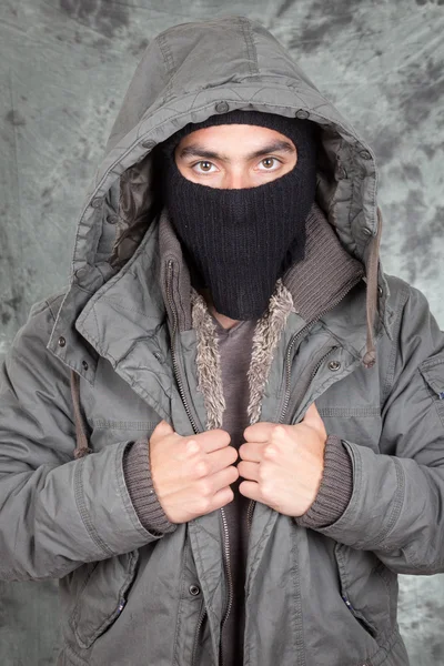 Unrecognizable man wearing black hoodie over grey blackground Royalty Free Stock Photos