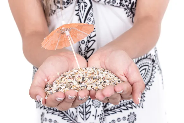 Hands carrying sand with two mini umbrellas — Stock Photo, Image