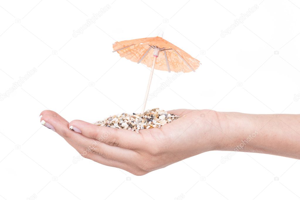 sand on hands with mini umbrella