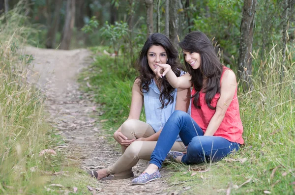 Duas meninas bonitas sentadas em uma floresta — Fotografia de Stock