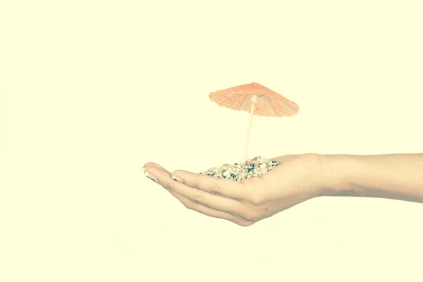 Písek na rukou s mini deštníky — Stock fotografie