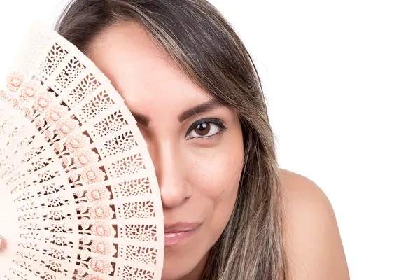 Young woman holding a fan in front of her face — Stock Photo, Image