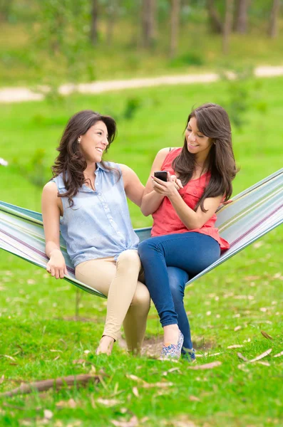 Two young girls resting on a hammock smiling — Stock Photo, Image