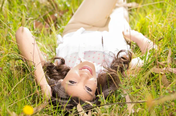 Bella giovane donna sdraiata su erba verde — Foto Stock