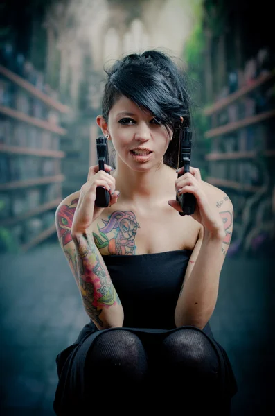 Provocative tattooed girl holding gun — Stock Photo, Image