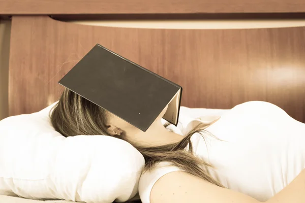 年轻女孩睡在一起她脸上的书 — 图库照片