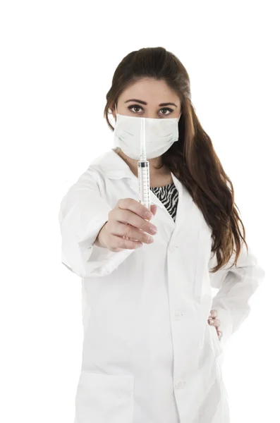 Bela médica amigável usando uma máscara segurando uma injeção — Fotografia de Stock