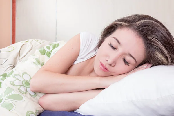 Hermosa joven acostada en la cama — Foto de Stock