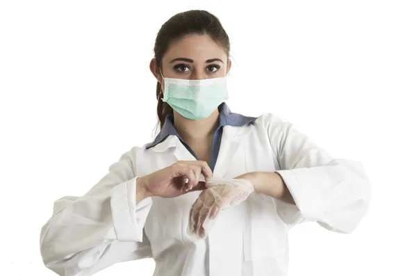 Jeune femme médecin portant des gants et un masque — Photo