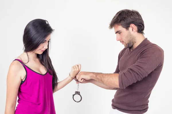 Attractive young couple with handcuffs — Stock Photo, Image