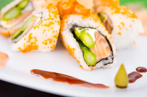 Rollos de sushi fresco con espárragos y caviar en un plato —  Fotos de Stock