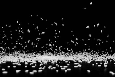 Pirinç taneleri siyah arkaplanda siyah bir yüzeye düşer. .