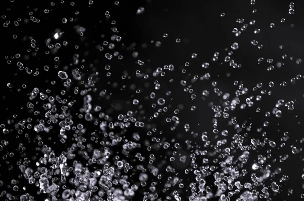 Burbujas de aire en el agua aisladas sobre fondo negro — Foto de Stock