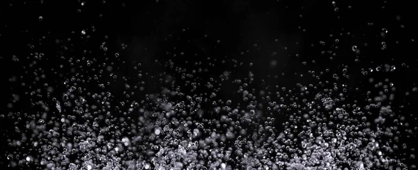 Luchtbellen in het water geïsoleerd op zwarte achtergrond — Stockfoto