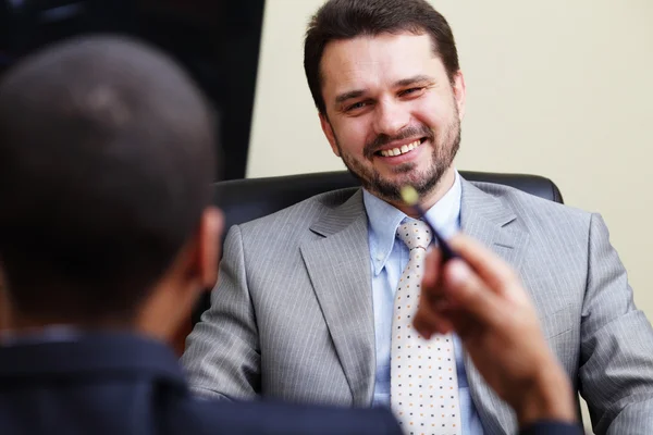 Mature businessman having great time while chating with his partner — Stock Photo, Image