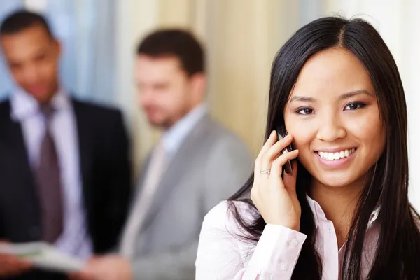 Junge glückliche asiatische Geschäftsfrau am Telefon — Stockfoto