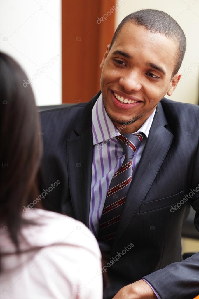 Young african-american businessman having a conversation with her coworker