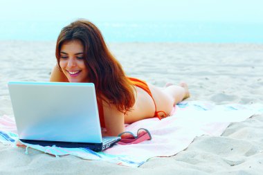Sahilde onun tablet kullanarak Yüzme elbiseli güzel kadın