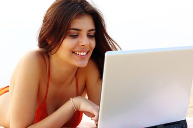 Sahilde onun tablet kullanarak Yüzme elbiseli güzel kadın
