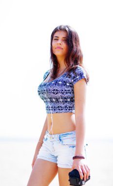 retro kamera ile sahilde yürüyen genç güzel kadın