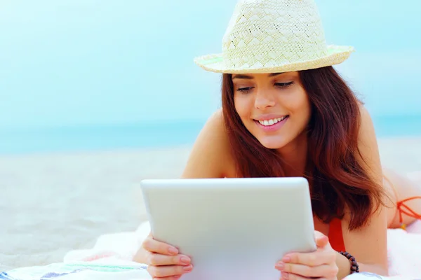 Mooie vrouw in zwemmen pak met behulp van haar Tablet PC op het strand — Stockfoto