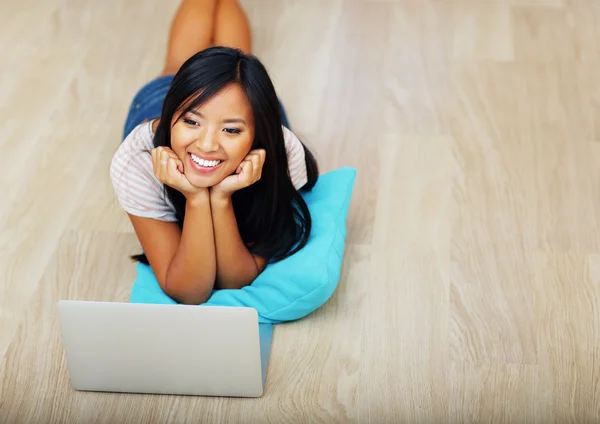 Mulher asiática deitada no chão com laptop — Fotografia de Stock