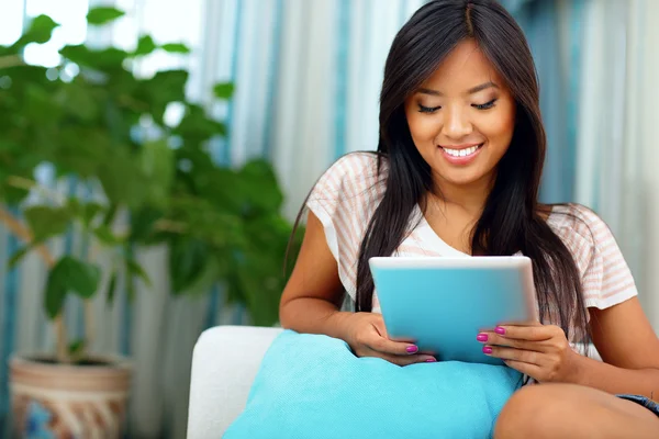 Feliz jovem asiático mulher navegação internet com seu tablet — Fotografia de Stock