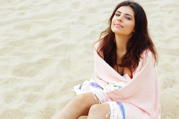 Mujer envuelta con manta en la playa — Foto de Stock