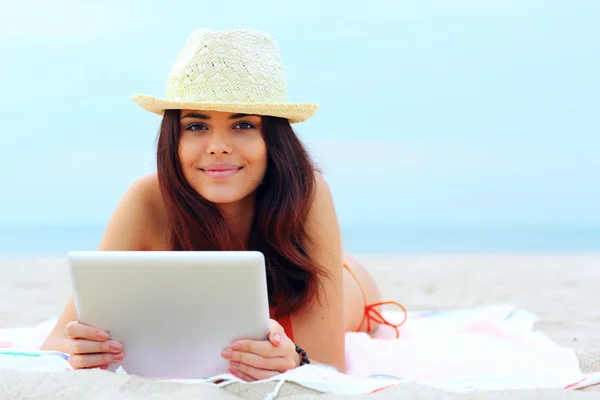 Mooie vrouw in zwemmen pak met behulp van haar Tablet PC op het strand — Stockfoto