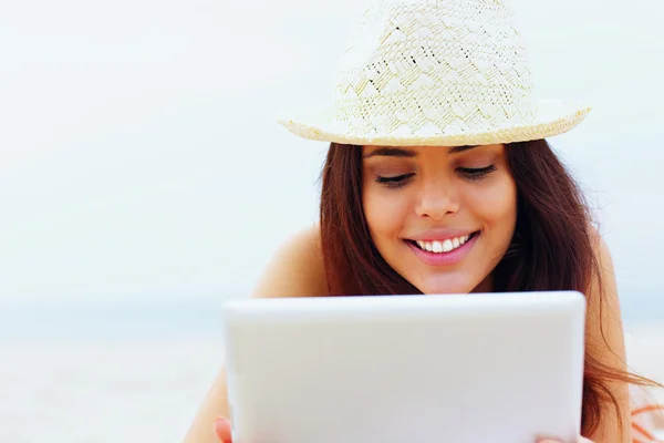 Mooie vrouw in zwemmen pak met behulp van haar Tablet PC op het strand — Stockfoto