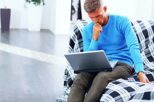 Jonge man aan het werk op laptop thuis geabsorbeerd — Stockfoto