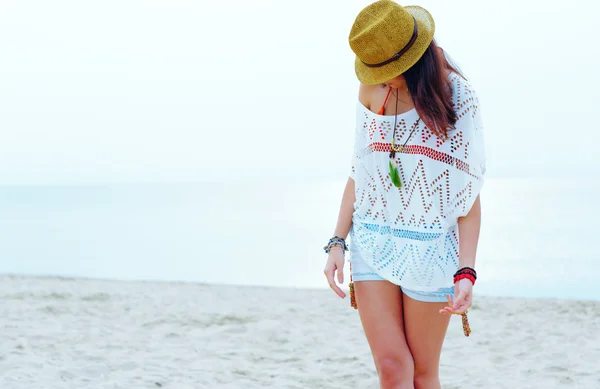 Молодая женщина в стильном наряде прогулка по пляжу — стоковое фото