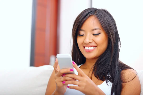 Jovem mulher asiática mensagens de texto com seu smartphone — Fotografia de Stock